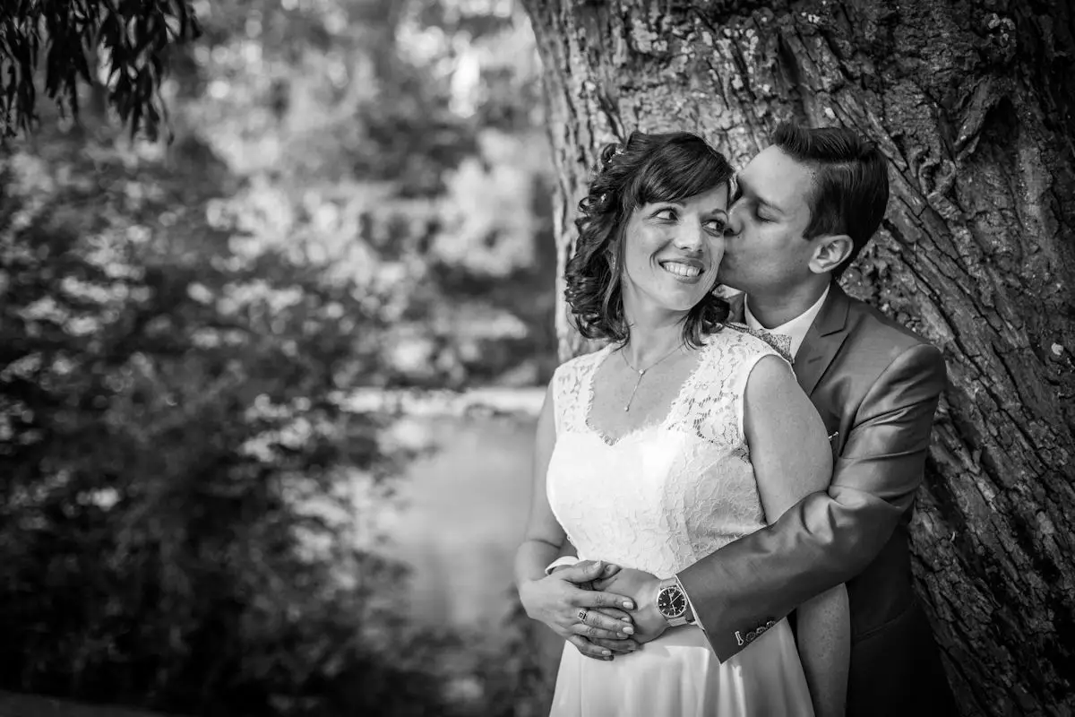 Baiser romantique des mariés au bord de l'eau